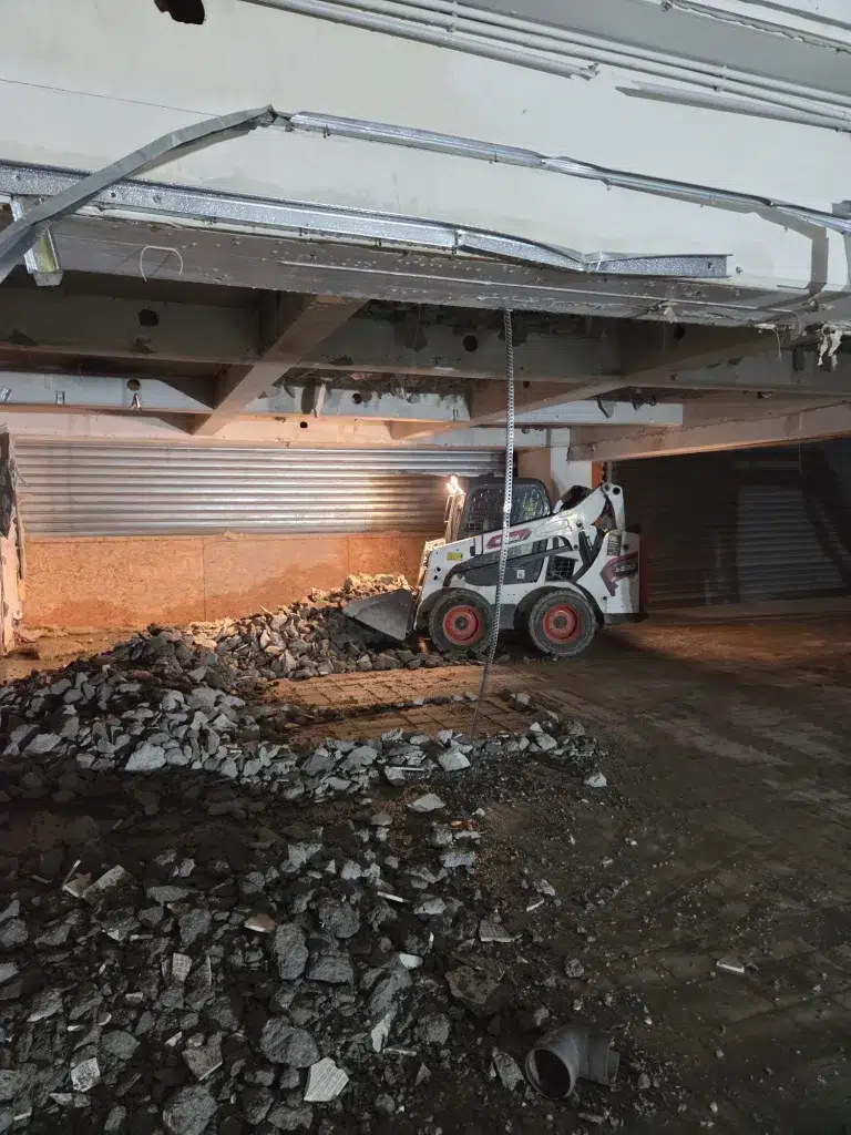 Miniîncărcător Bobcat evacuează molozul rezultat din demolarea interioară a unei clădiri